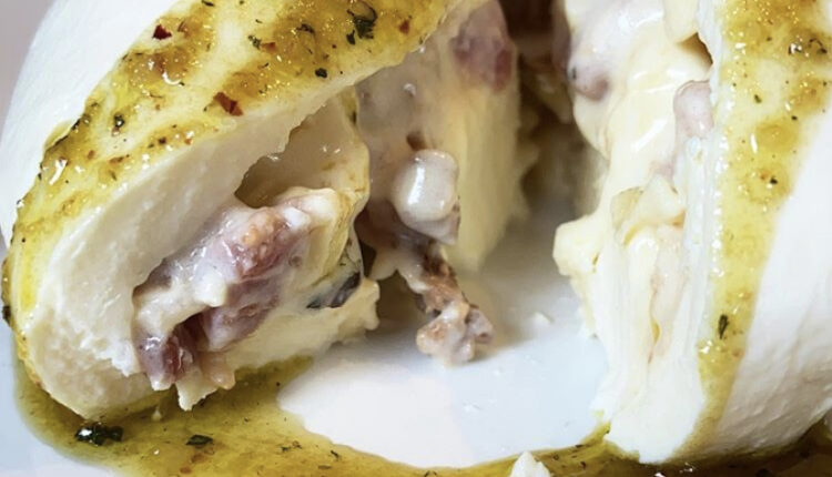 Burrata recheada com stracciatella e bacon servida com pesto de erva-mate e pinhão