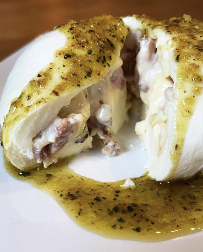 Burrata recheada com stracciatella e bacon servida com pesto de erva-mate e pinhão